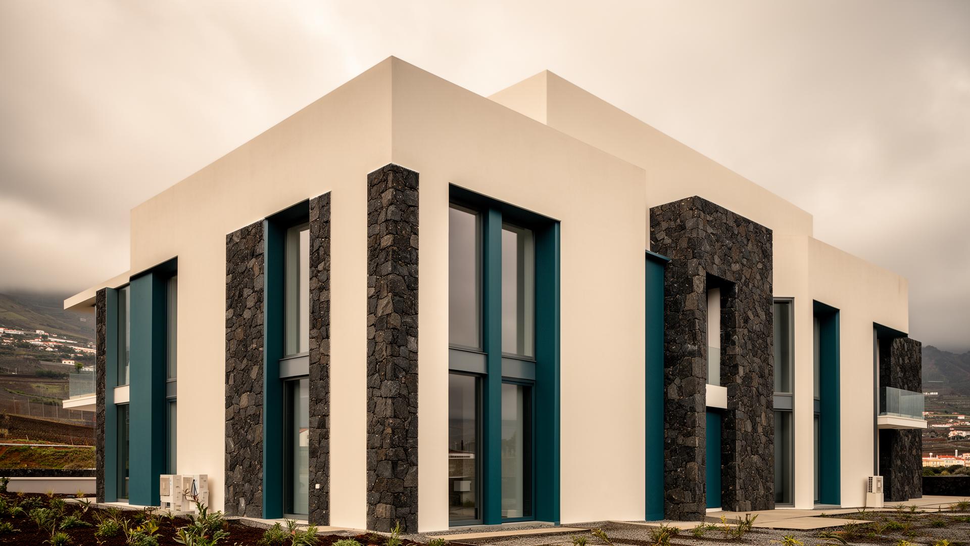 Arquitetura contemporânea portuguesa: edifício com fachada em pedra basáltica e reboco branco